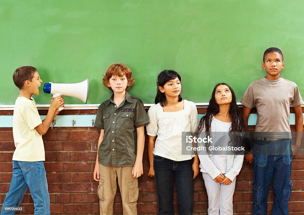 School boy con un megáfono amarillo en clase a - Foto de stock de Niño libre de derechos