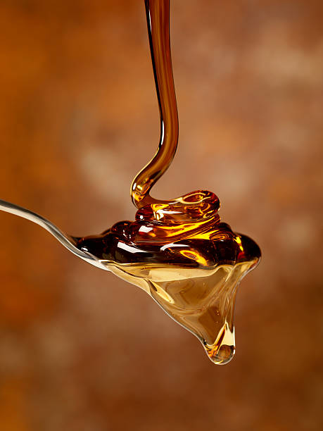Pouring Maple Syrup over a Spoon stock photo