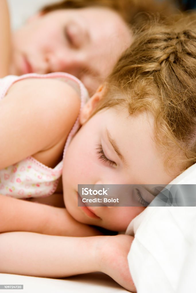 Niña durmiendo con la madre en el fondo - Foto de stock de Acostado libre de derechos