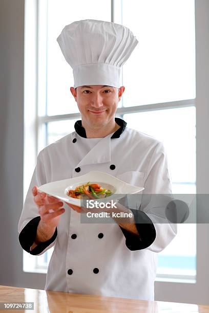 Orgulhoso Chefe De Cozinha Apresentando Refeição - Fotografias de stock e mais imagens de Barrete - Chapéu - Barrete - Chapéu, Chefe de Cozinha, Sexo Masculino