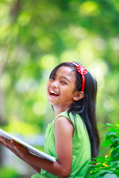 bella bambina lettura libro - outdoors looking at camera little girls child foto e immagini stock