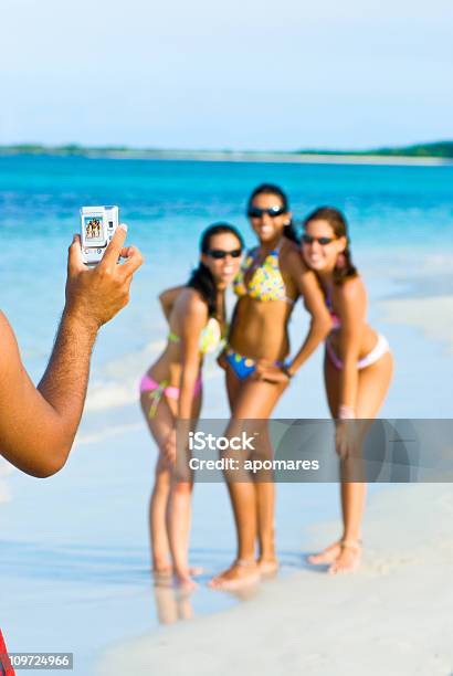 Uomo Prendendo Foto Di Giovane Donna In Posa Sulla Spiaggia - Fotografie stock e altre immagini di 18-19 anni