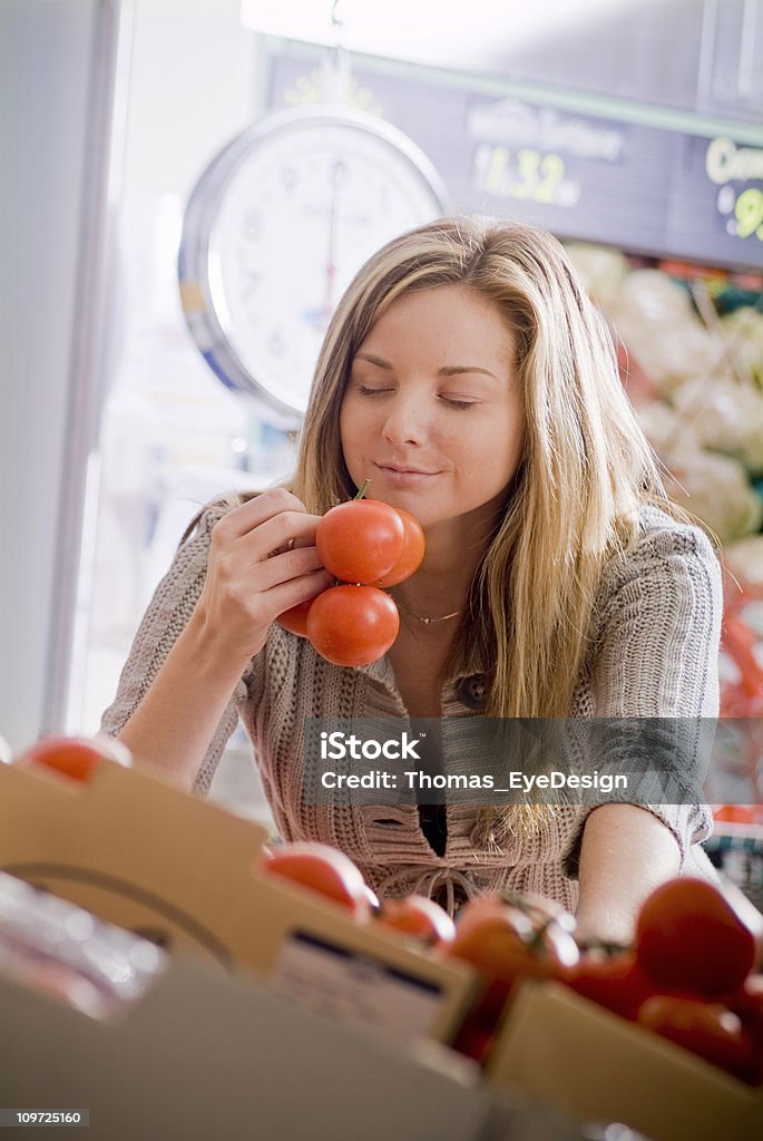Giovane donna i pomodori profumati nel mercato - Foto stock royalty-free di Donne