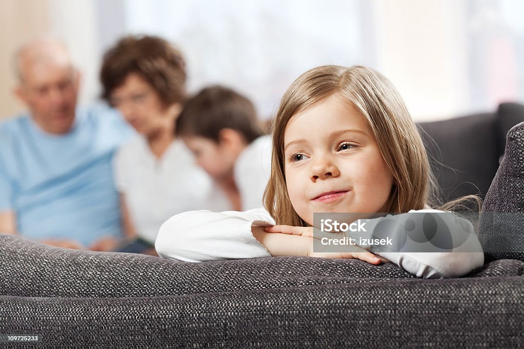 Linda niña abajo en sofá y sonriendo - Foto de stock de Abuelos libre de derechos