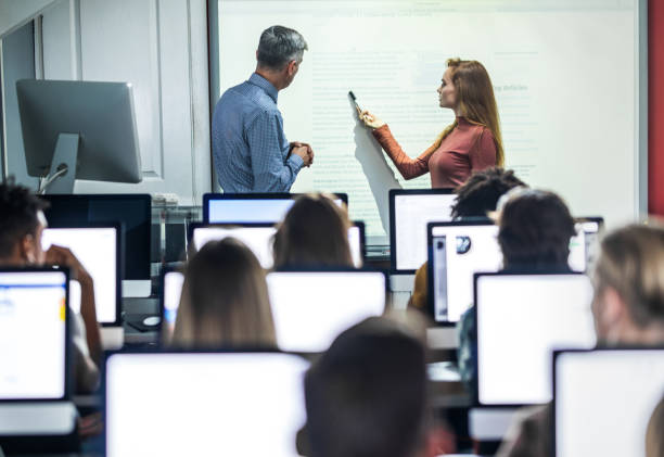 istock Female student talking to a professor about the lecture at computer class. 1097253040