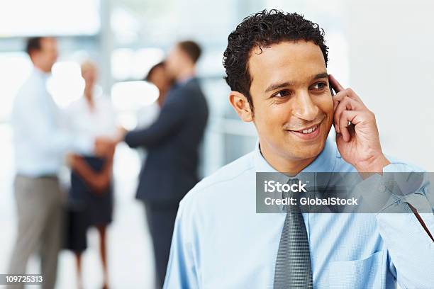 ハンサムビジネス男笑顔を使用して携帯電話での作業 - 20-24歳のストックフォトや画像を多数ご用意 - 20-24歳, 25-29歳, 30-34歳