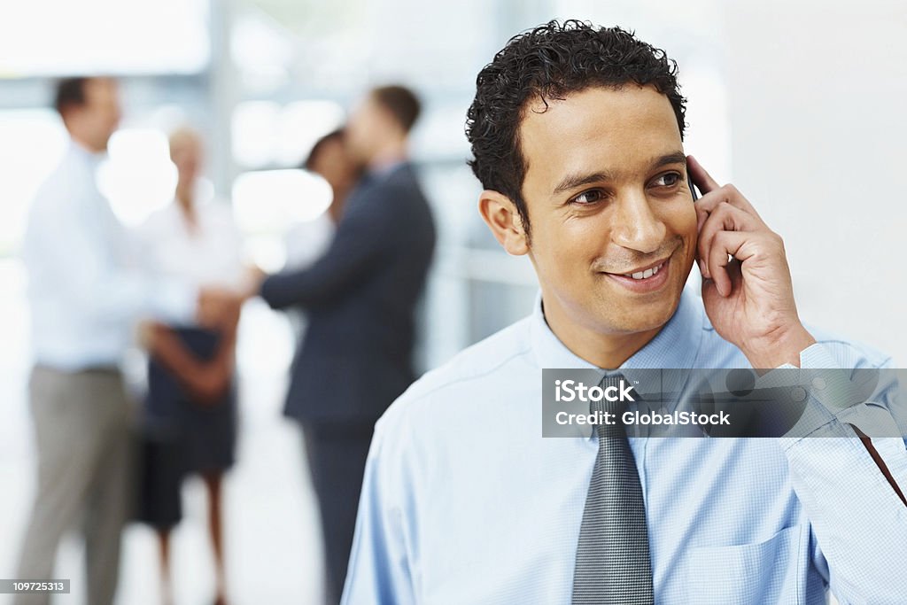 미소 비즈니스 사�용하는 잘생긴 남자 휴대폰 직장에서 - 로열티 프리 20-24세 스톡 사진