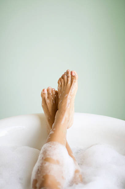 frau beine und füße in der badewanne mit blasen - ein bad nehmen fotos stock-fotos und bilder
