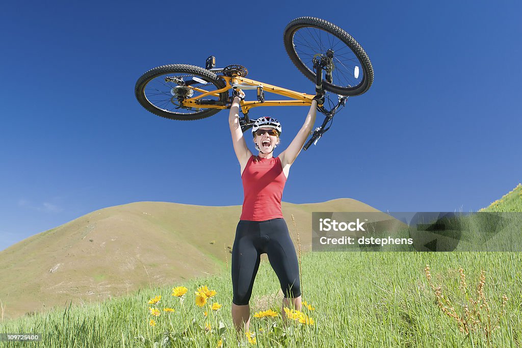 Athlétique jeune femme en vélo sur la colline au-dessus de la tête - Photo de Aboutissement libre de droits