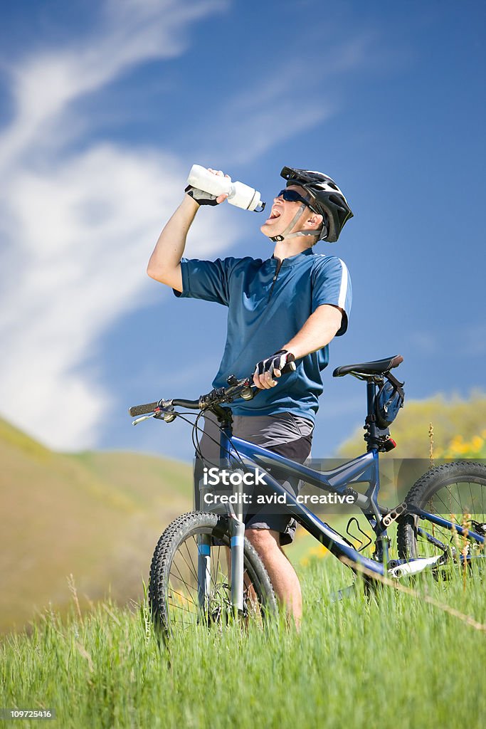 Ciclista di Mountain bike acqua potabile - Foto stock royalty-free di Adulto