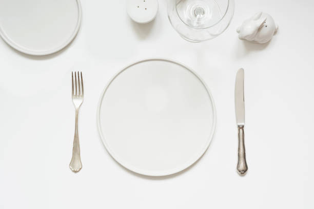 Festive modern white table setting. Plates and cutlery on white background. Top view.