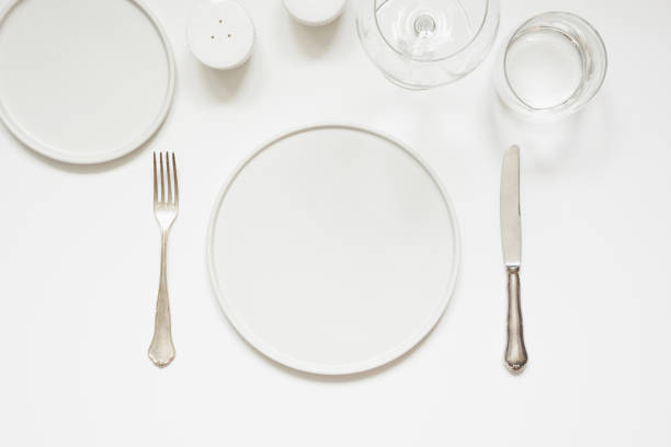 istock Festive modern white table setting. Plates and cutlery on white. View from above. 1097254748