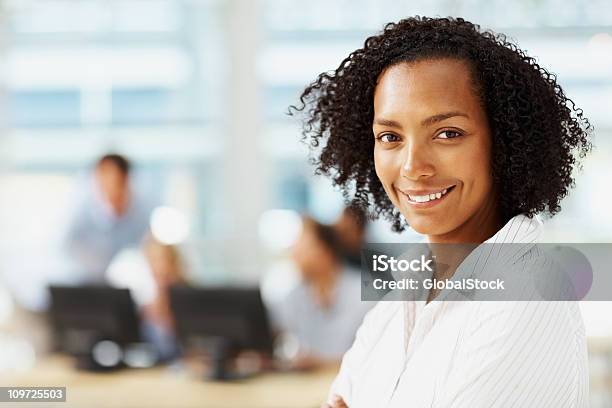 Retrato De La Sonriente Executive Con Colegas En El Fondo Foto de stock y más banco de imágenes de Africano-americano