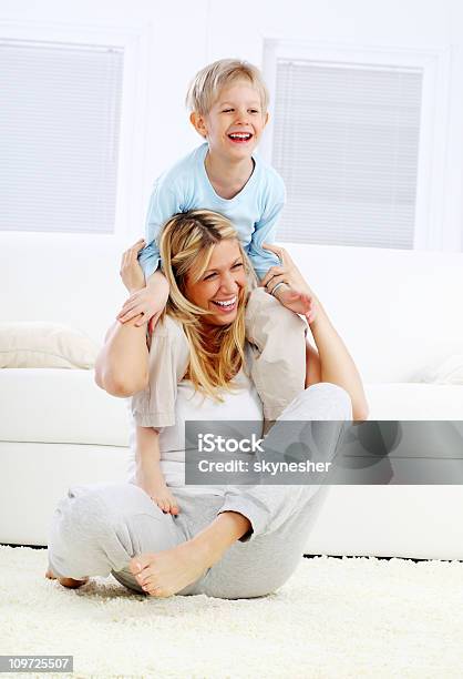 Boy Sitting On The Back Of His Mother Stock Photo - Download Image Now - Child, Clambering, Mother