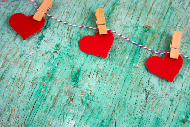 corações de papel dia dos namorados, pendurado em uma linha de sequência de caracteres - love hanging indoors studio shot - fotografias e filmes do acervo