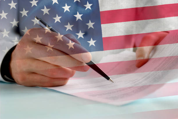 istock Businessman signing papers with US flag overlay 1097255528