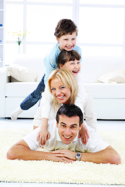 glückliche familie festlegung einer der anderen. - carpet floor lying down people stock-fotos und bilder