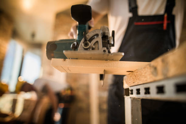istock Close up of unrecognizable worker cutting plank with circular saw at construction site. 1097257762