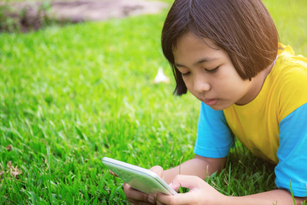 istock Girls are using tablet on lawn. 1097257940