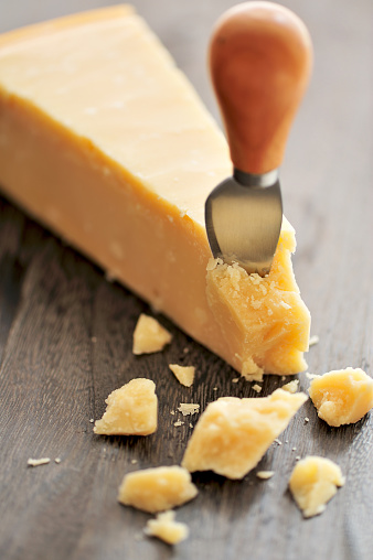 An aged authentic parmigiano reggiano - parmesan cheese on rustic wood