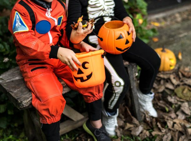 Little children trick or treating on Halloween Little children trick or treating on Halloween halloween treats stock pictures, royalty-free photos & images