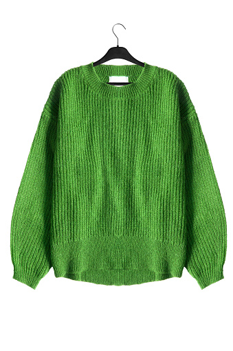 Green wool sweater on black clothes rack isolated over white