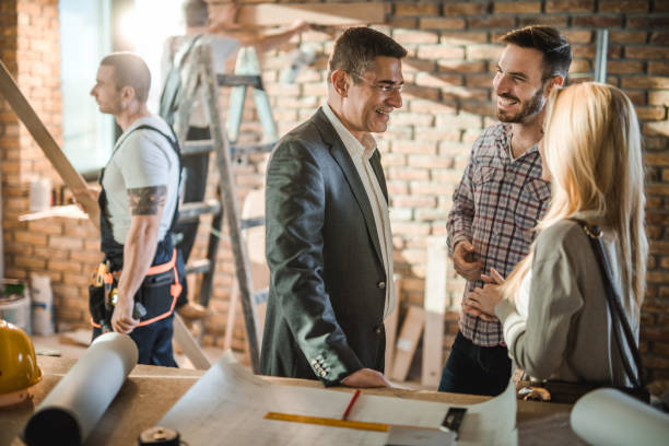 istock Happy architect talking to couple during home improvement process. 1097261424