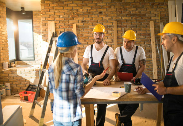 istock Female building contractor giving instructions to group of workers on construction site. 1097261886