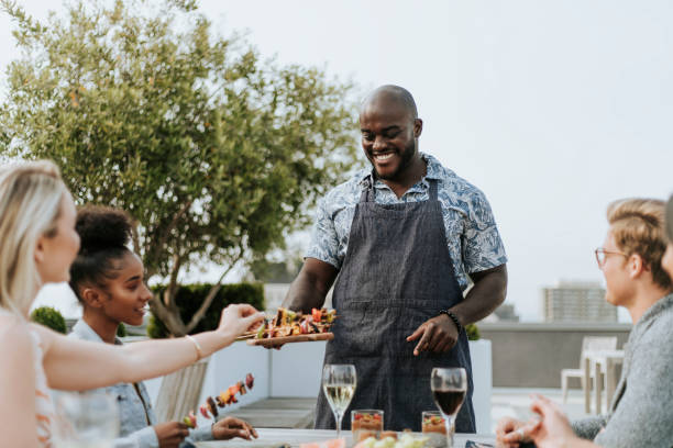 Cheerful chef serving grilled vegan barbeque skewers