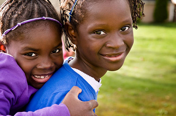 Two Happy Girls Smiling and Hugging Outside