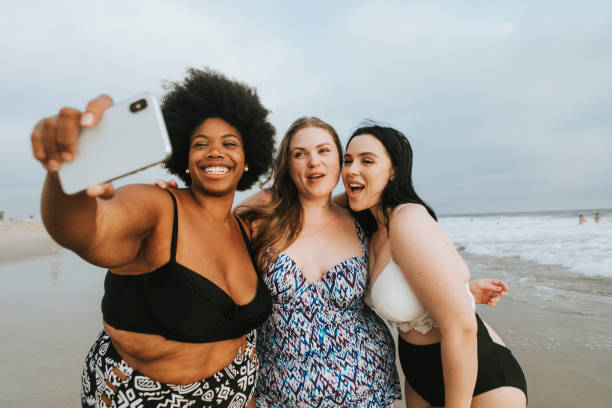 istock Beautiful curvy women taking a selfie at the beach 1097263326
