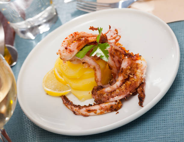 istock Delicious cooked squid or octopus tentacles with lemon and parsley on a plate 1097263674