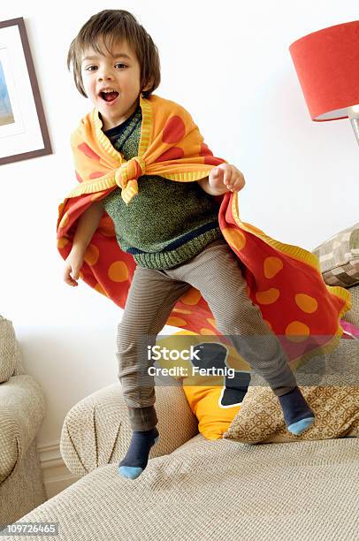 Foto de Pequeno Menino Usando Toalha Cabo E Saltar No Sofá e mais fotos de stock de Pular