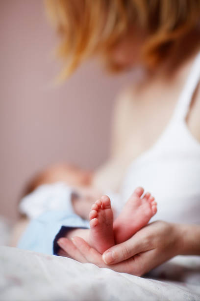 mujer en período de lactancia y suavemente el recién nacido bebé retención de cuadrados - newborn baby human foot photography fotografías e imágenes de stock