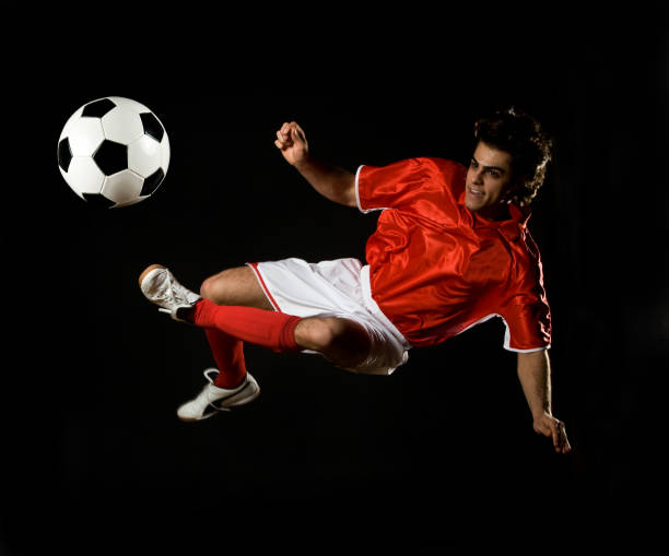istock Soccer Player Doing Flying Kick with Ball, Isolated on Black 109726599