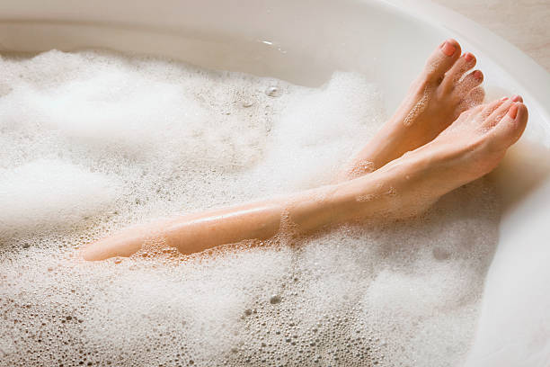 woman's legs & feet in bubble bath - woman foot stockfoto's en -beelden