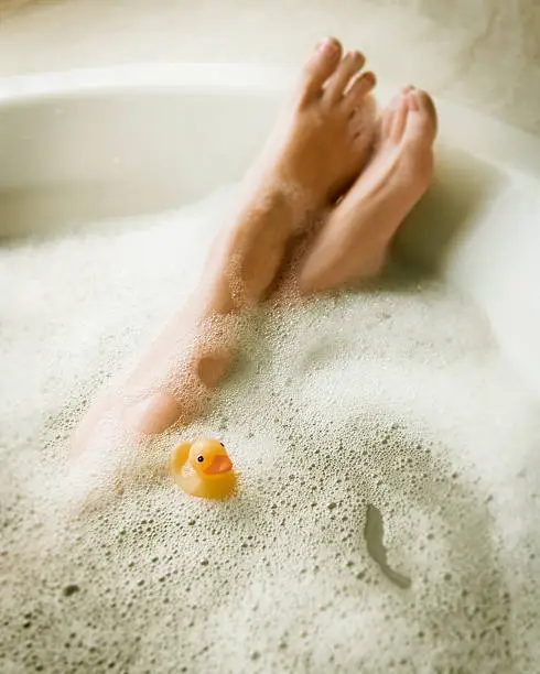 Woman in bathtub. Bubble Bath. Vertical shot.