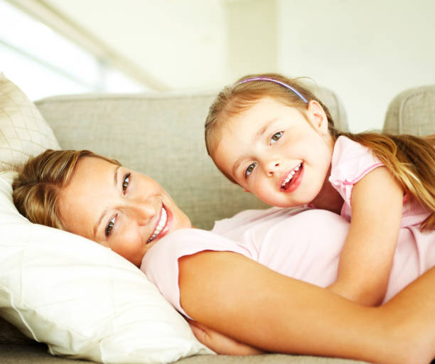 istock Mother with her daughter lying on sofa and smiling 109726762