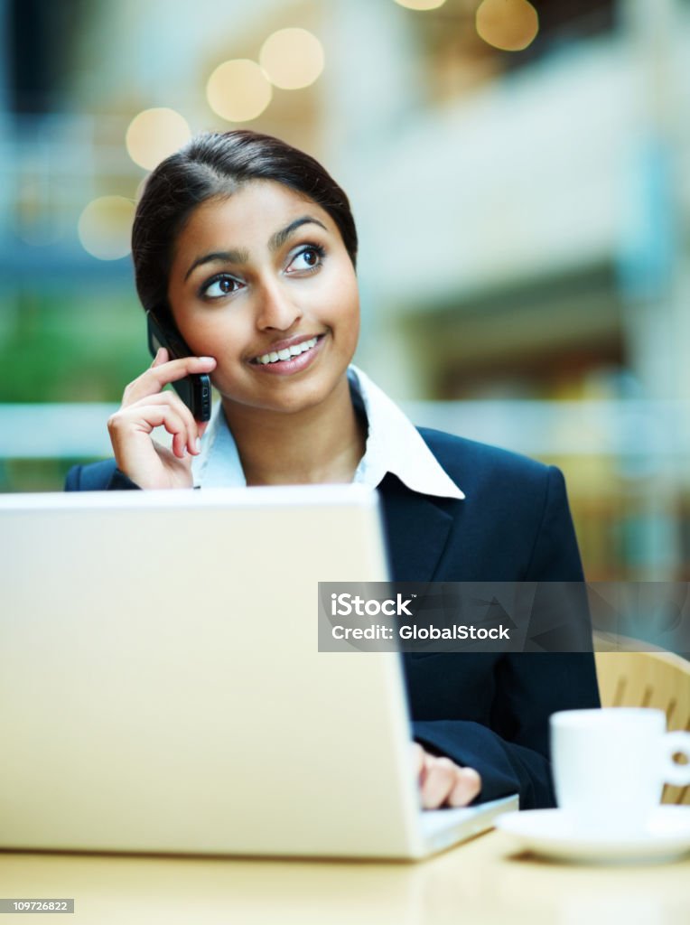 Donna d'affari di parlare al cellulare e utilizzando computer portatile - Foto stock royalty-free di Colletti bianchi