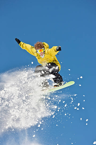 istock Snowboarder Jumping In Mid-Air Against Blue Sky 109726855