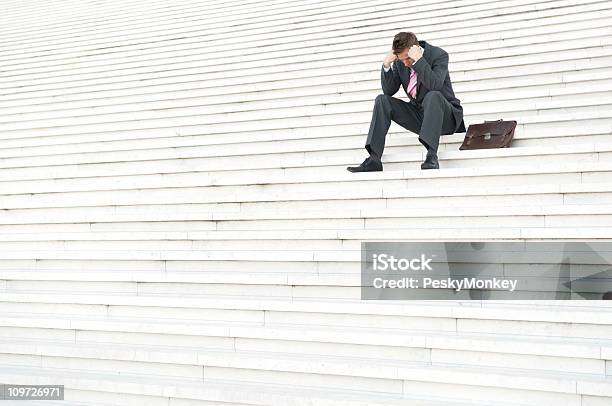 Depressed Businessman Sitting Outdoors On Steps With Head Down Stock Photo - Download Image Now