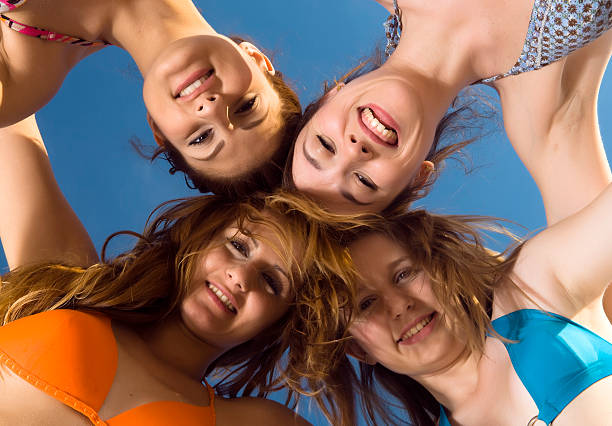 istock Low Angle View of Four Young Girls Huddling on Beach 109726997