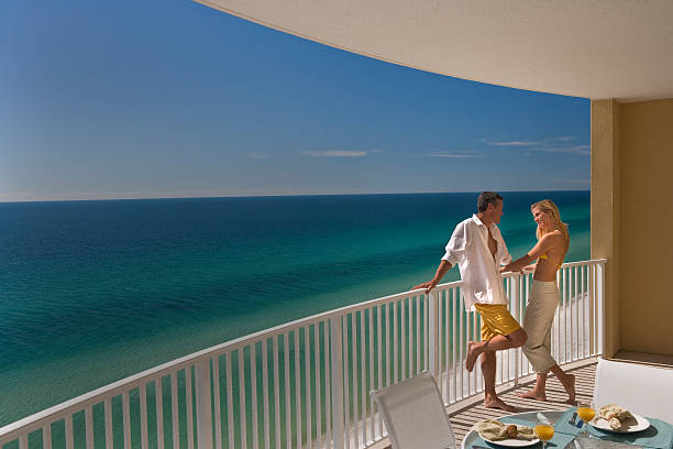 Couple Standing On Balcony Overlooking Gulf of Mexico stock photo