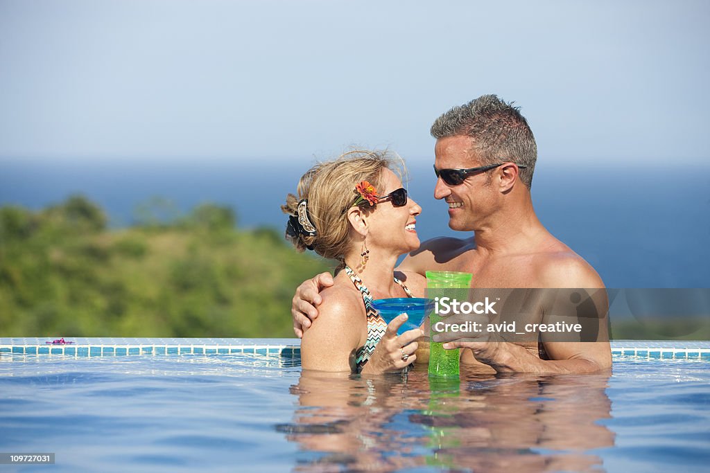 Estilo de vida de vacaciones de la pareja romántica en la piscina del hotel - Foto de stock de 40-49 años libre de derechos