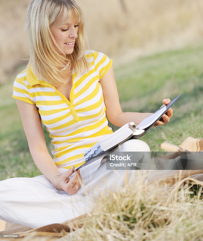 金髪の女性屋外で勉強の草原 - 1人のロイヤリティフリーストックフォト