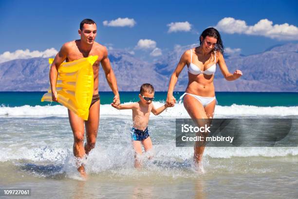 Familia Feliz Divirtiéndosen La Playa Foto de stock y más banco de imágenes de Adulto - Adulto, Agarrar, Aire libre