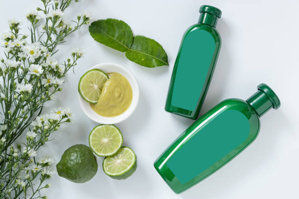 natural products for hair concept. two size of green plastic bottle with blank label contain herbal bergamot shampoo decorate with slide kaffir limes ,kaffir leaf and white flowers on white background natural products for hair concept. two size of green plastic bottle with blank label contain herbal bergamot shampoo decorate with slide kaffir limes ,kaffir leaf and white flowers on white background kaffir stock pictures, royalty-free photos & images