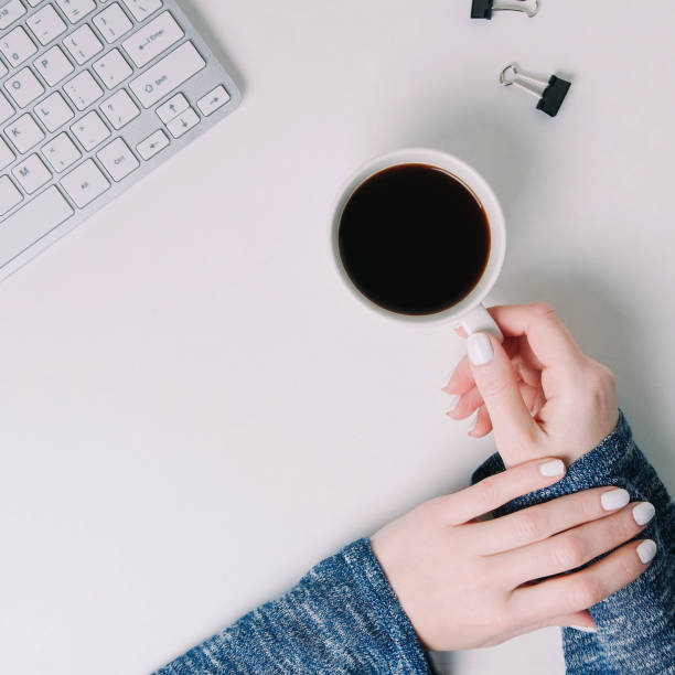 istock Woman holding a Cup of coffee in her hands. Top view 1097271458