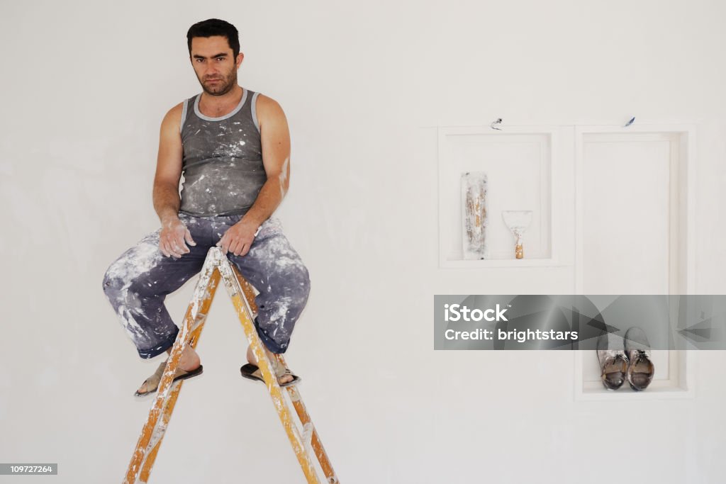 Plâtre Travailleur assis sur l'échelle - Photo de Peintre libre de droits