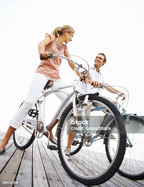 Felice Giovane Coppia Seduta Sulle Biciclette - Fotografie stock e altre immagini di 25-29 anni - 25-29 anni, Abbigliamento casual, Adulto